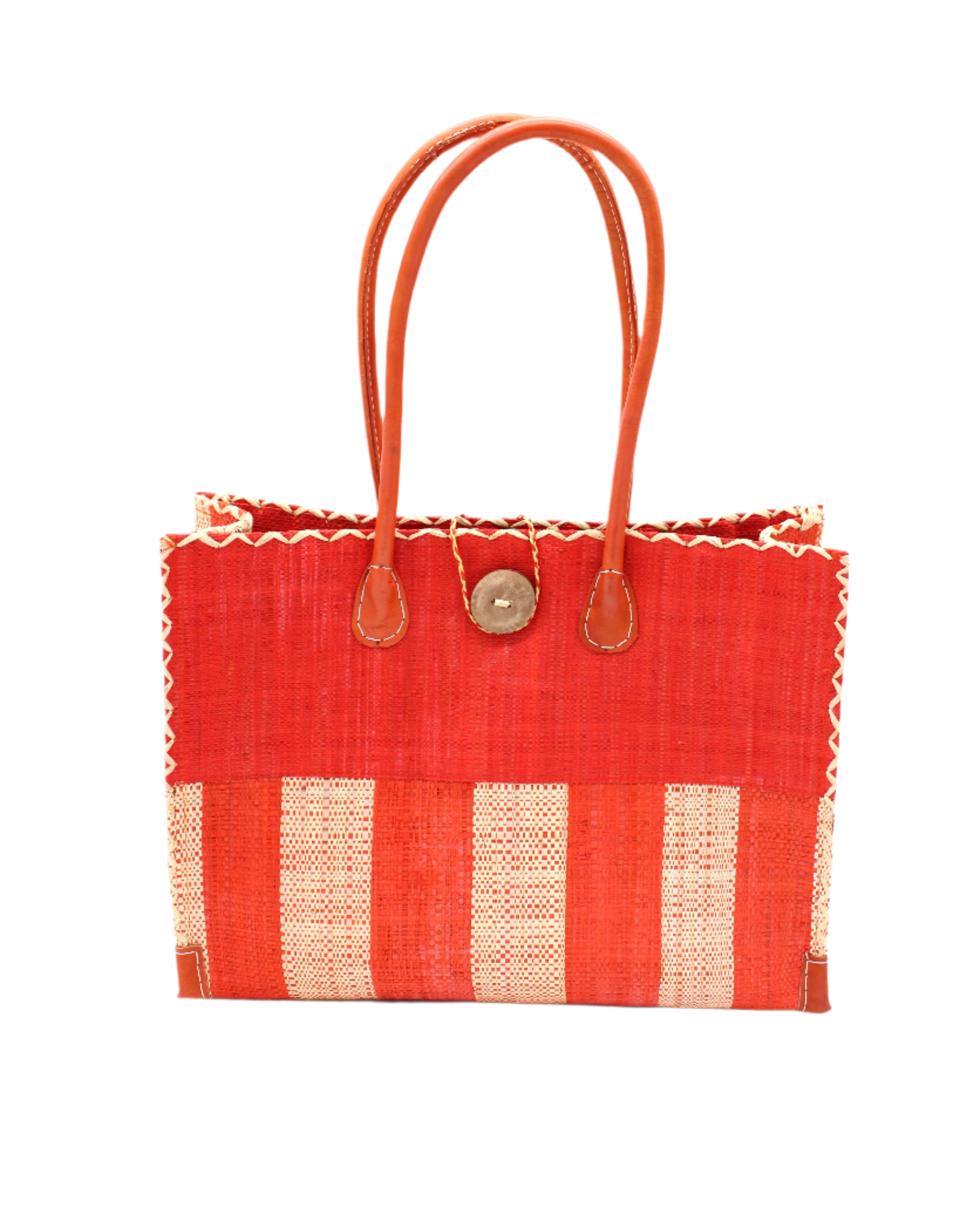 Zafran Two Tone Wide Stripe Coral and Natural Straw Beach Bag handmade loomed raffia palm fiber in a solid hue of coral orange/red on the top half of the bag and a two tone even width vertical wide stripe pattern of coral and natural straw color on the bottom half of the bag with leather handles and feet and matching crosshatch stitch edging shoulder bag - Shebobo
