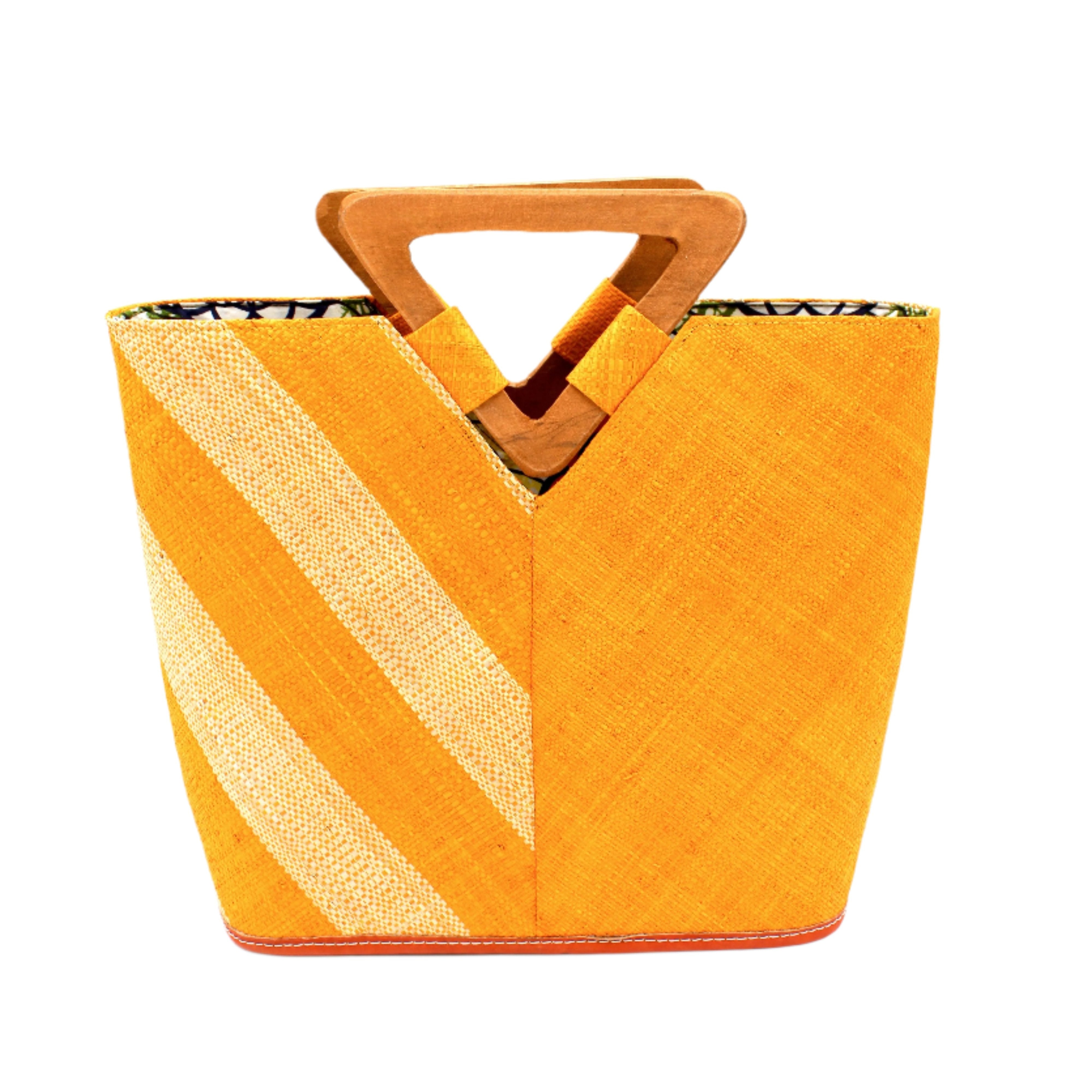 Zuki Two Tone Saffron Straw Handbag With Wood Triangle Handle handmade loomed raffia palm fiber in a two tone pattern with the left half of the bag even width stripes of saffron yellow/orange and natural straw color oriented as a diagonal stripe and the right half of the bag a solid hue of saffron with carved wood handles - Shebobo
