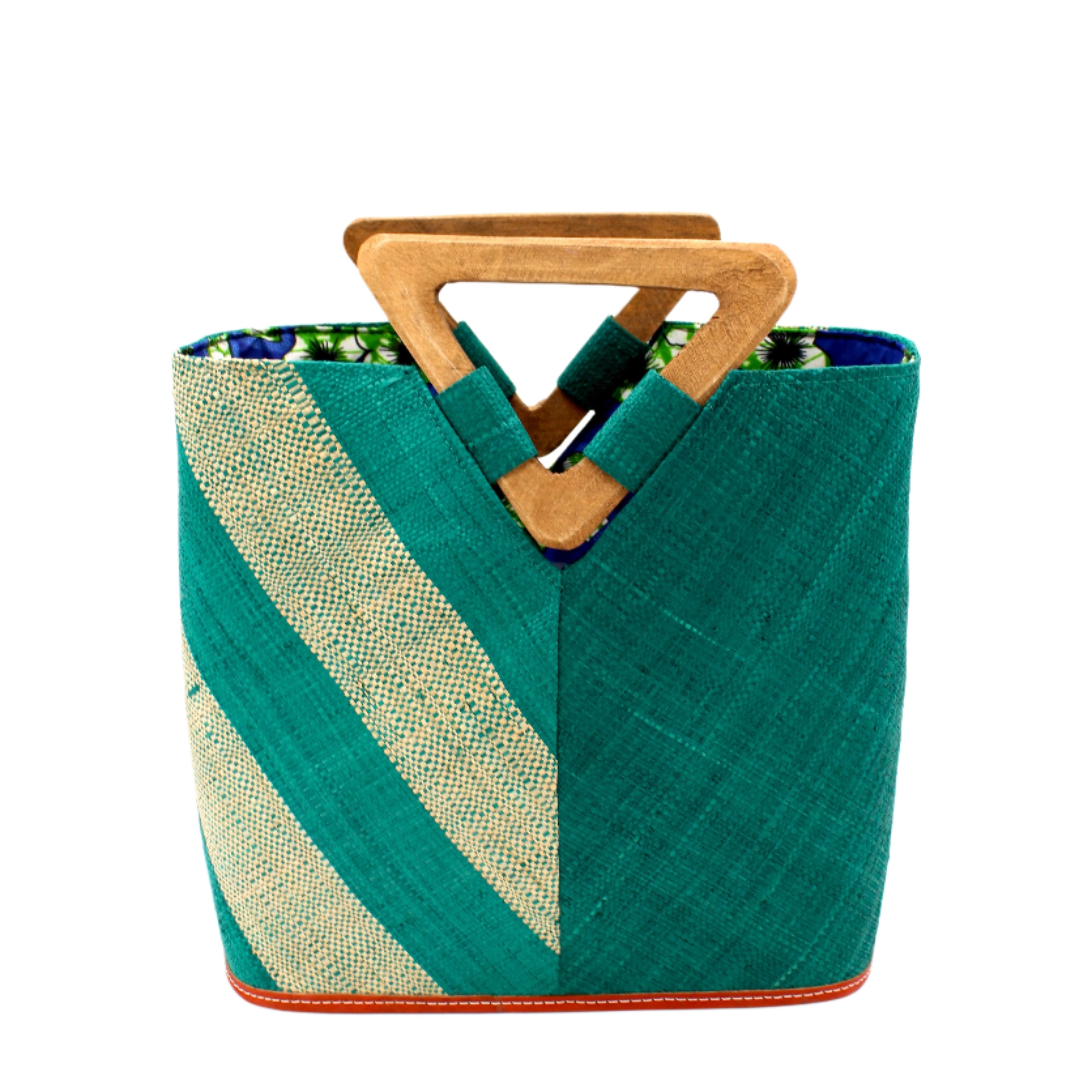 Zuki Two Tone Teal Straw Handbag With Wood Triangle Handle handmade loomed raffia palm fiber in a two tone pattern with the left half of the bag even width stripes of teal dark/blue/green and natural straw color oriented as a diagonal stripe and the right half of the bag a solid hue of teal with carved wood handles - Shebobo