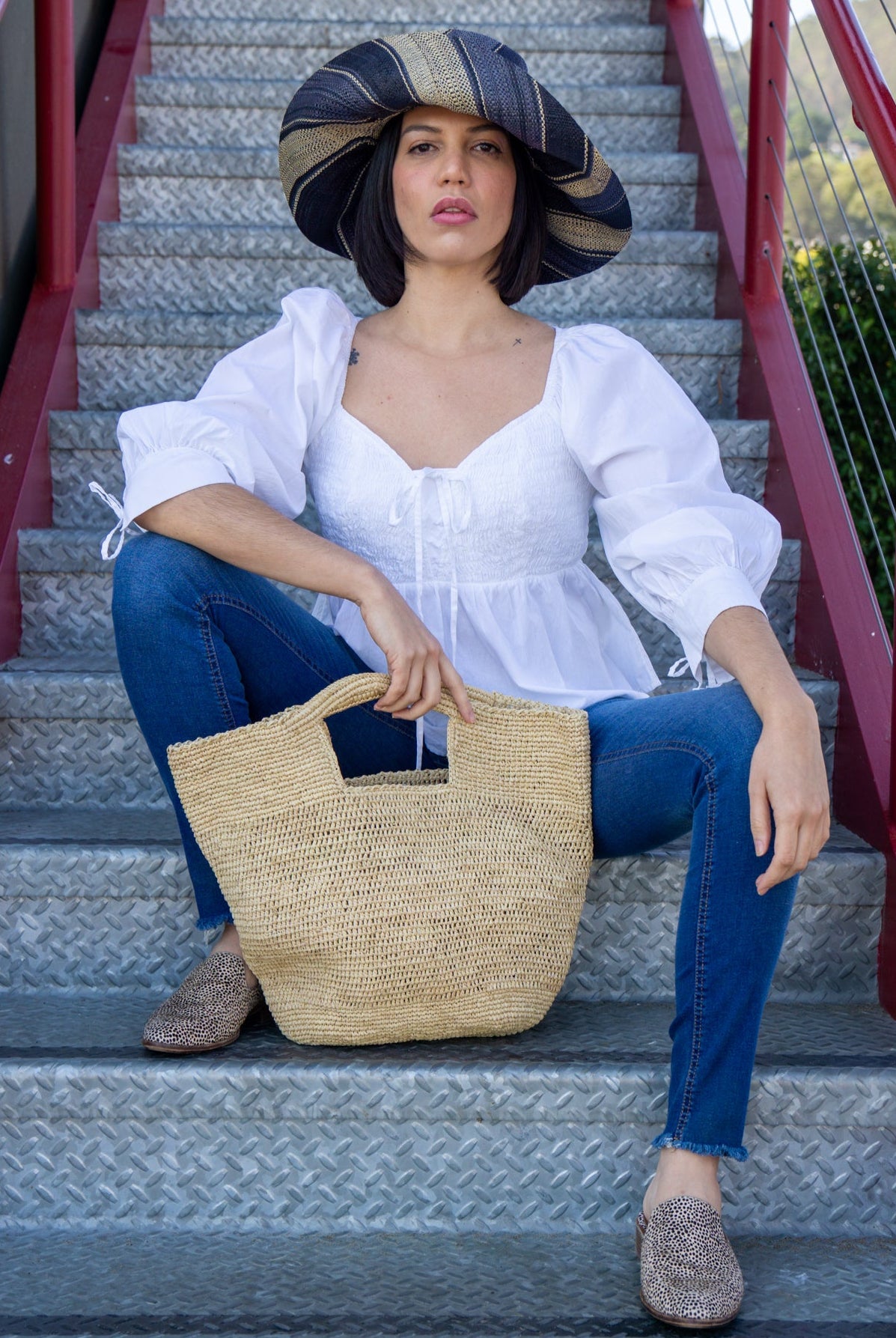 Model wearing ConCon crochet straw basket natural raffia straw color handbag textural bag - Shebobo (with 5" Brim Black Swirl Packable Straw Sun Hat)