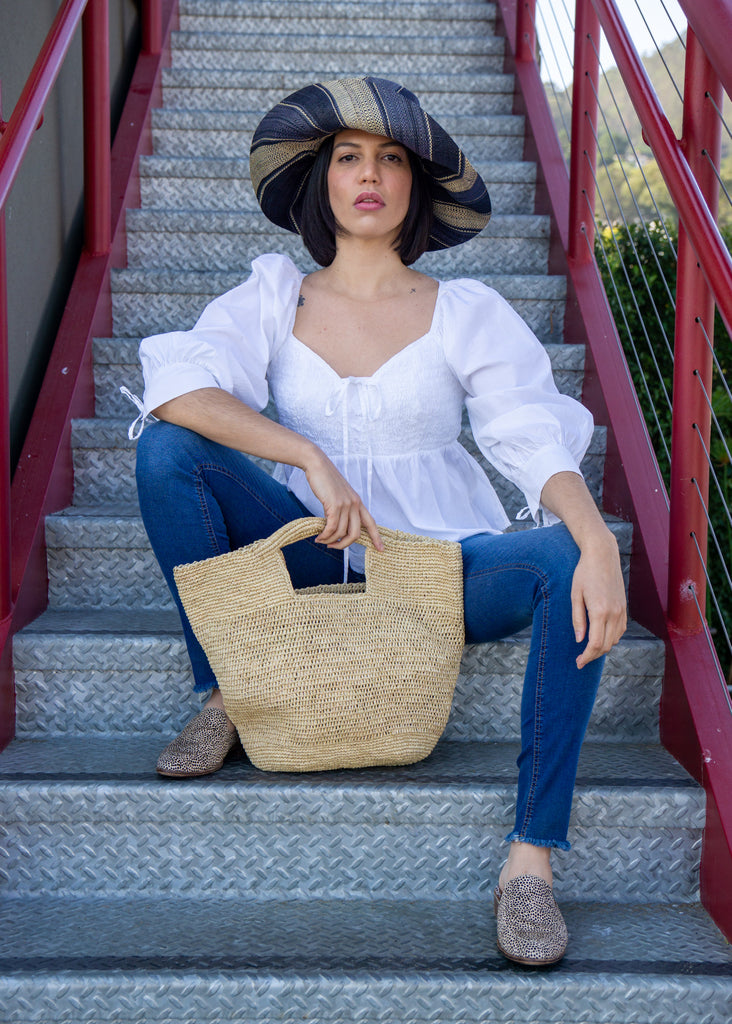 Model wearing ConCon crochet straw basket natural raffia straw color handbag textural bag - Shebobo (with 5" Brim Black Swirl Packable Straw Sun Hat)