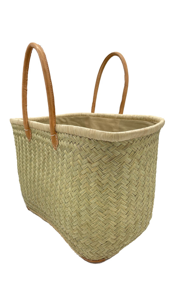 Tan Tan handmade woven natural rush and raffia straw fiber basket tote bag available in small, medium, or large with leather handles side angle - Shebobo