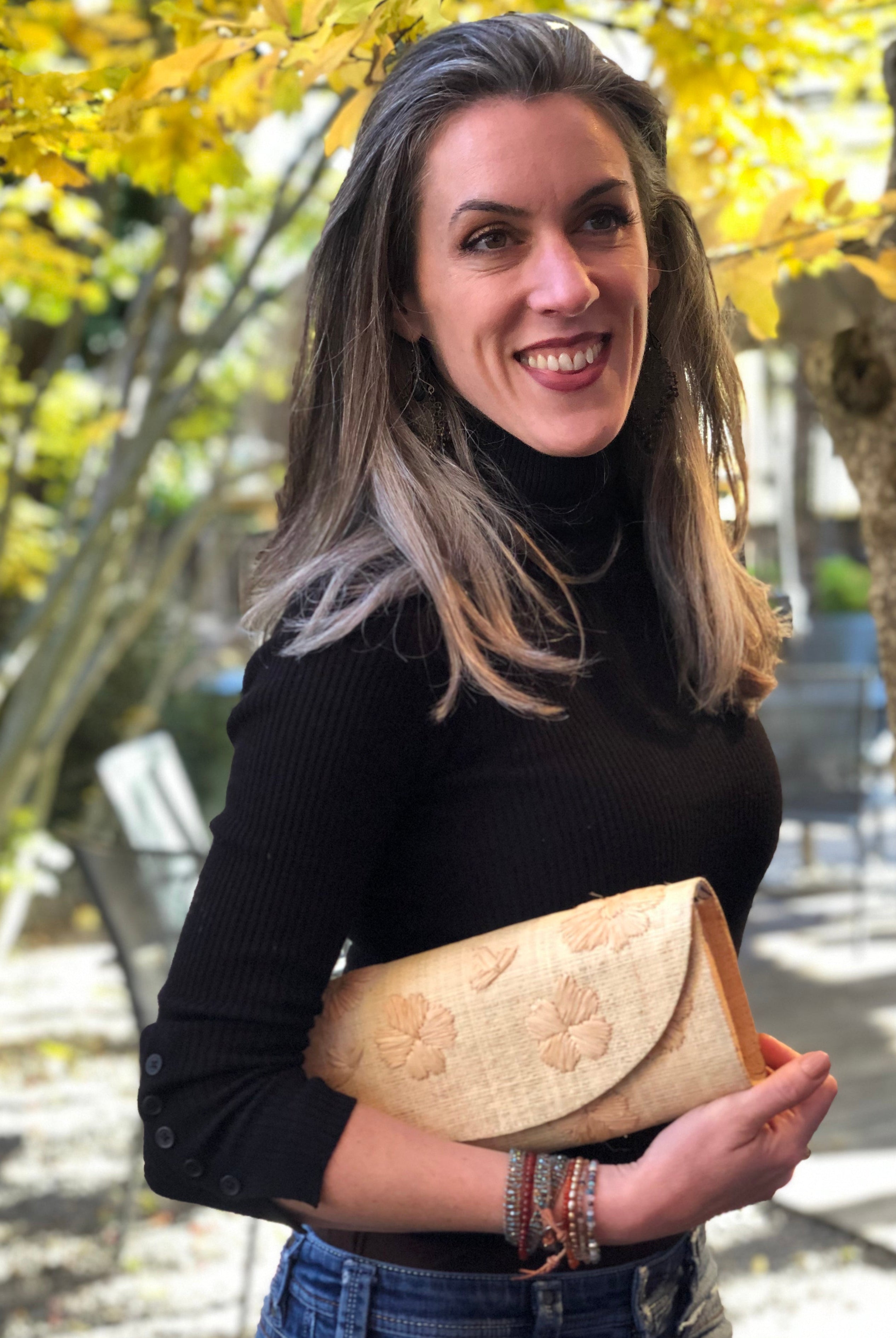 Model wearing Tulum Flower Clutch Handbag with Hand Embroidery handmade loomed natural straw colored raffia pillbox shape purse with natural stitched flower pattern small bag - Shebobo