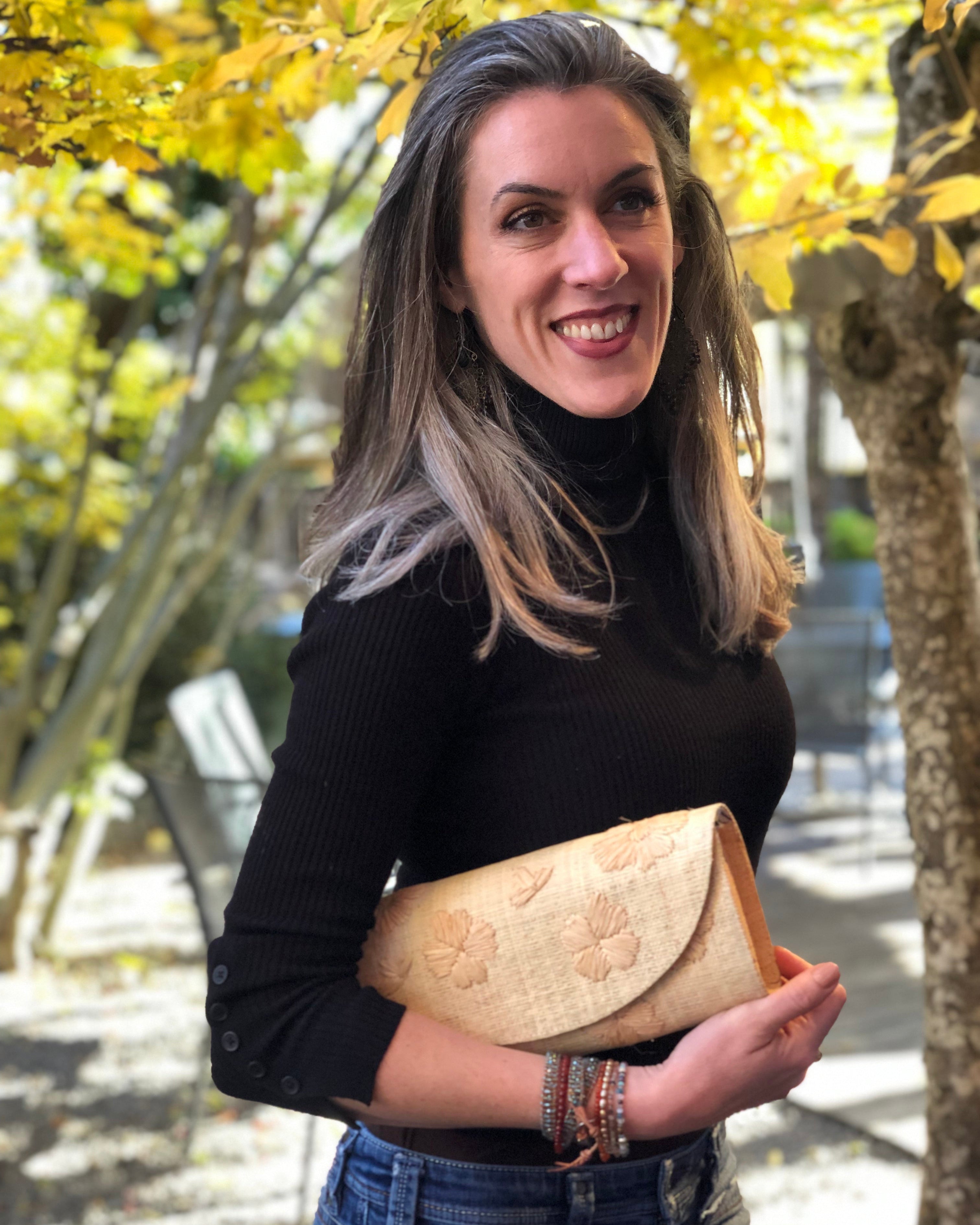 Model wearing Tulum Flower Clutch Handbag with Hand Embroidery handmade loomed natural straw colored raffia pillbox shape purse with natural stitched flower pattern small bag - Shebobo