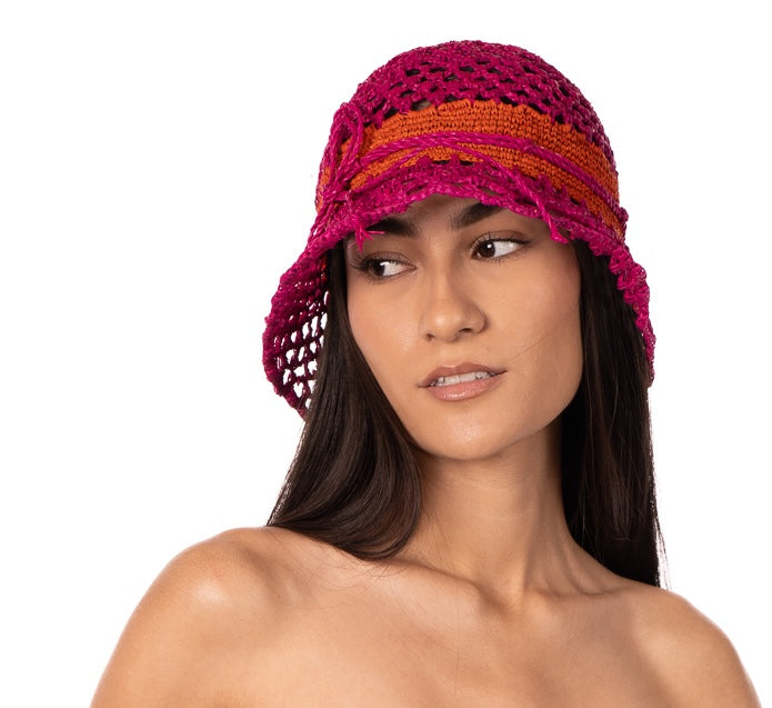 Model wearing 2.5" Brim Maria Fuchsia Crochet Bucket Straw Hat handmade raffia palm fiber crochet in an open loop wave/shell pattern of fuchsia/hot/bright/barbie pink with a close weave crochet hat band in contrasting coral orange/red with adjustable hat band straw sun hat - Shebobo