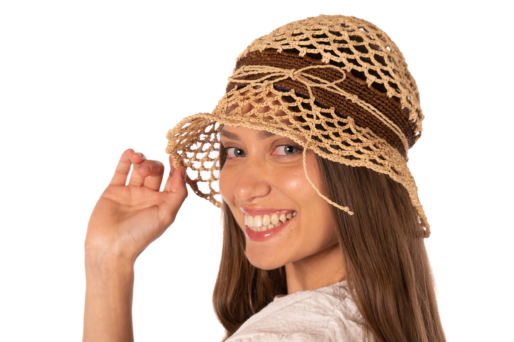 Model wearing 2.5" Brim Maria Natural Crochet Bucket Straw Hat handmade raffia palm fiber crochet in an open loop wave/shell pattern of natural straw color with a close weave crochet hat band in contrasting cinnamon/tobacco/brown with adjustable hat band straw sun hat - Shebobo