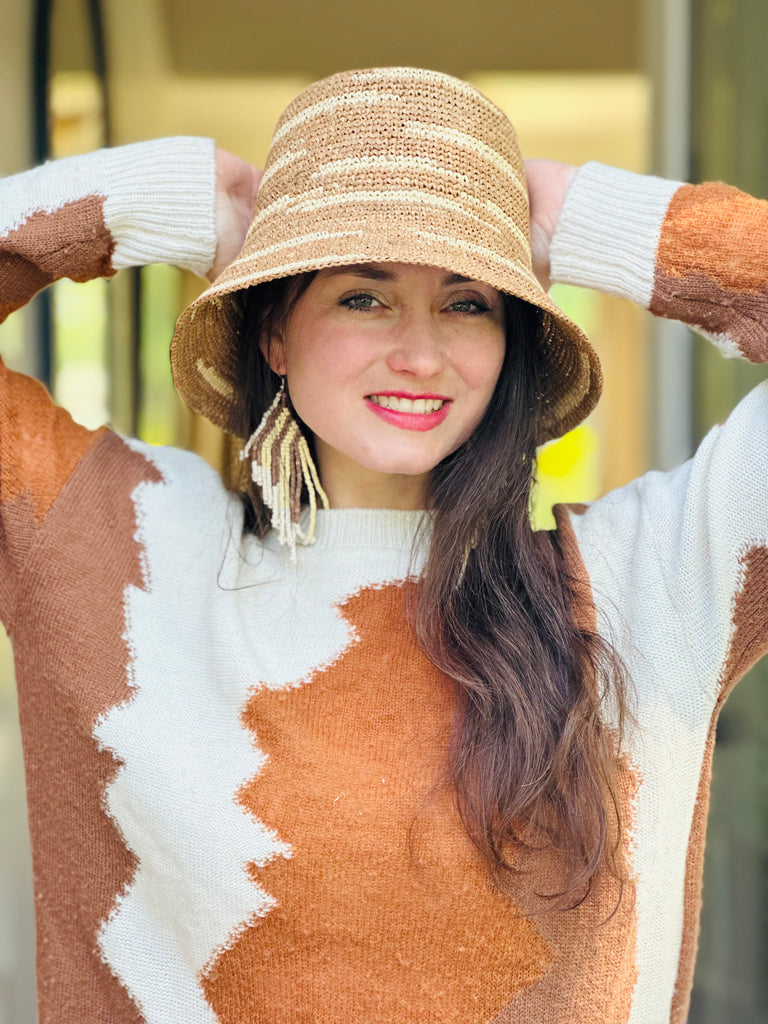 Model wearing 2.5" Brim Taylor Cappuccino Crochet Bucket Straw Hat with Zebra Stripes handmade raffia palm fiber in a two tone color combination of horizontal short stripes that create a dash pattern around the hat in Cappuccino light brown with natural straw color - Shebobo