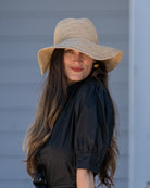 Model wearing Crochet Miramar Straw Sun Hat handmade woven raffia palm fiber in a subtle link pattered solid hue of natural straw color with matching adjustable braided hat band tie wide brim unisex panama style hat - Shebobo