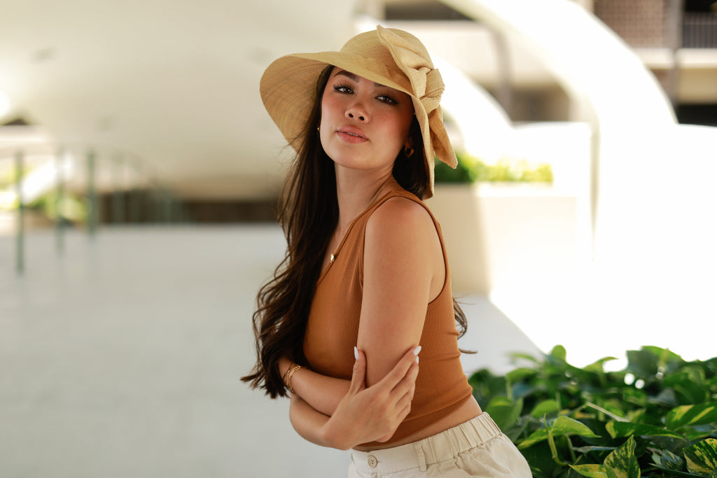 Model wearing Cara Natural straw color big bow embellishment handmade loomed raffia straw bucket style cloche sun hat - Shebobo