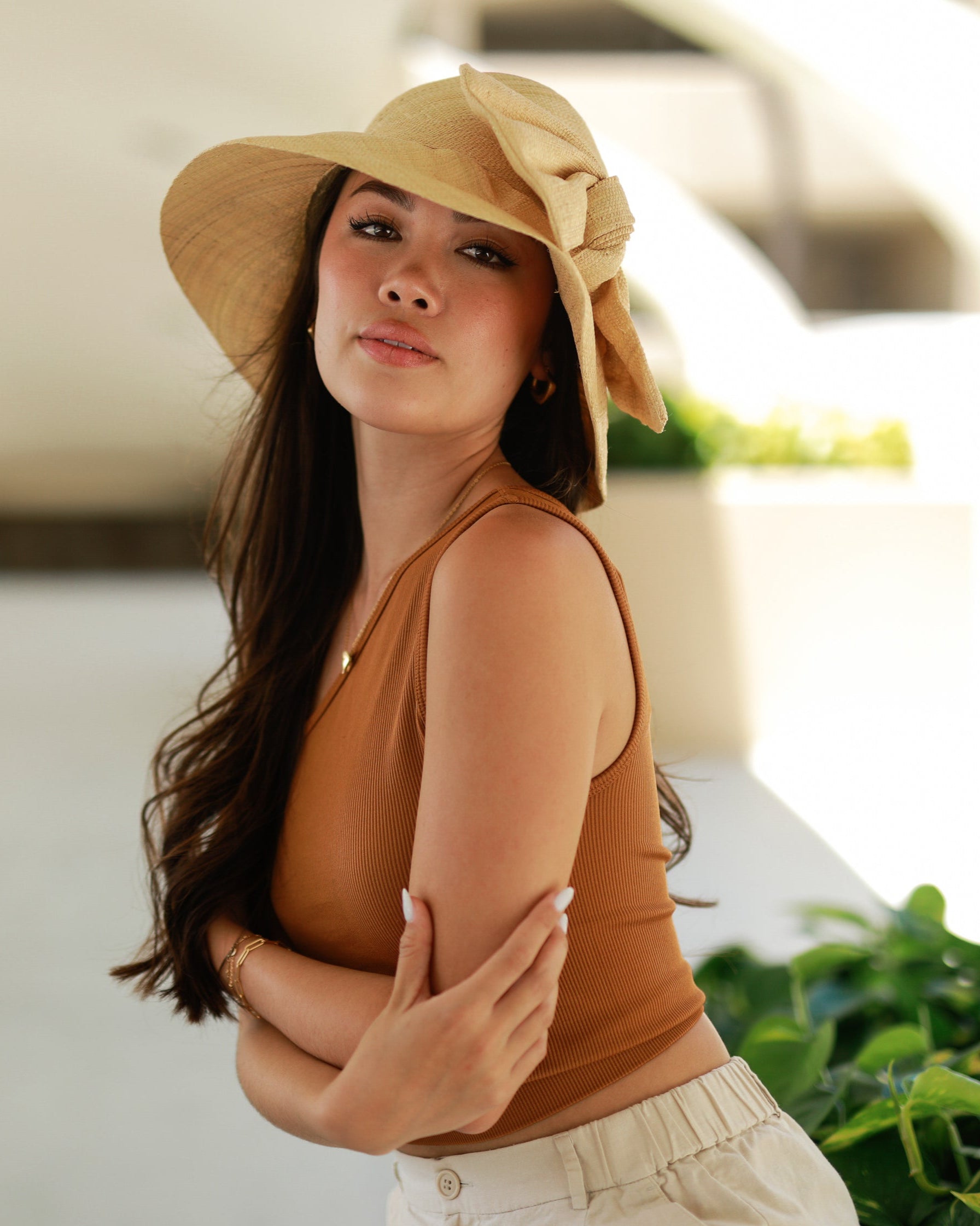 Model wearing Cara Natural straw color big bow embellishment handmade loomed raffia straw bucket style cloche sun hat - Shebobo