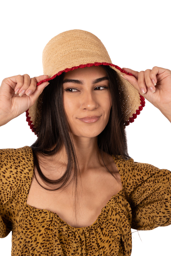 Model wearing Kate Natural with Red Crochet Bucket Straw Hats with Colored Lace Weave Edge handmade woven raffia palm fiber in a solid hue of natural straw color in a subtle link texture with red lace weave floral edge trim around the outer brim two tone multicolor uv protection hat - Shebobo