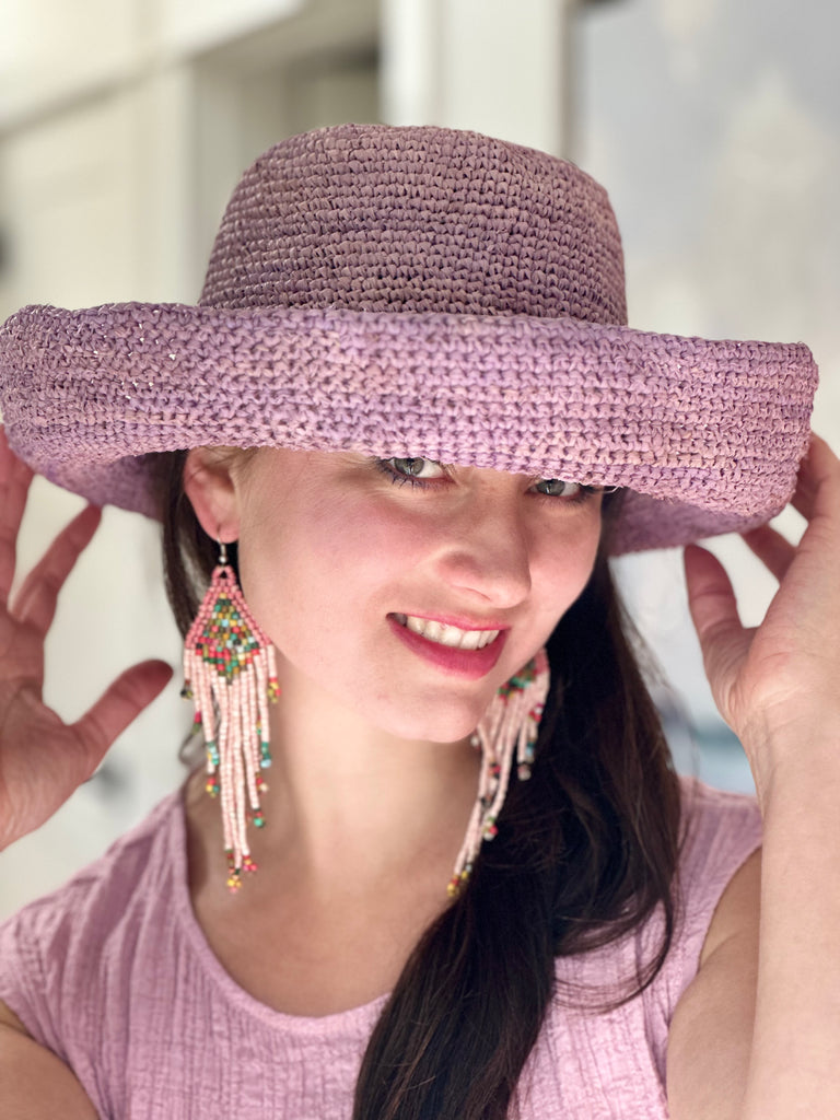 Model wearing Leor Wisteria crochet straw hat handmade wisteria/lilac/lavender/pale purple color raffia 3" brim packable straw hat with matching adjustable braided hat band - Shebobo