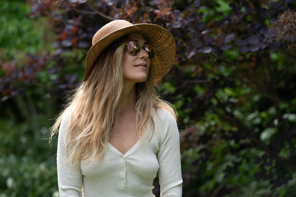 Model wearing 3" Brim Marsea Cinnamon Two Tone Melange Straw Sun Hats handmade loomed natural raffia palm fiber in a two tone color block aesthetic of solid cinnamon tobacco/dark/brown on the crown and hatband with multicolor melange heathered pattern swirl of cinnamon and natural straw color on the brim lightweight breathable packable hat - Shebobo