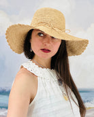 Model wearing 4" Brim Genevieve Natural Crochet Straw Sun Hat with Lace Weave Edge handmade raffia palm fiber crochet solid hue natural straw color rounded crown with detailed lace weave edge and matching adjustable hat band - Shebobo