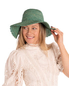 Model wearing 4" Brim Genevieve Seafoam Crochet Straw Sun Hat with Lace Weave Edge handmade raffia palm fiber crochet solid hue seafoam blue/green rounded crown with detailed lace weave edge and matching adjustable hat band - Shebobo