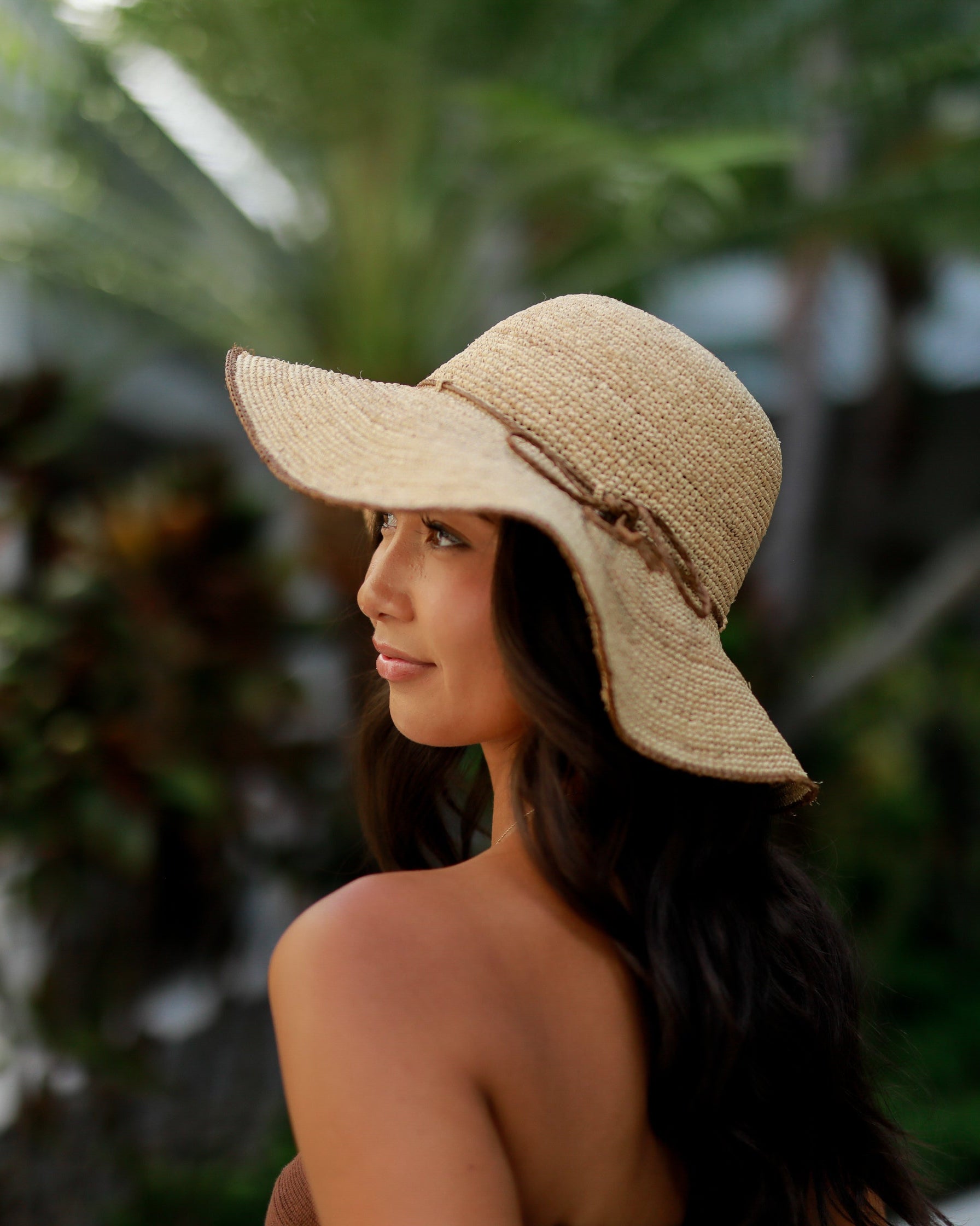 Model wearing 4" Brim Rachel Cinnamon Crochet Straw Sun Hat handmade crochet natural raffia palm fiber hat with dark brown/cinnamon/tobacco edge and matching corded hat band - Shebobo