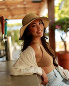 Model wearing 4 inch brim Rachel Crochet grey handmade straw sun hat grey trim woven edge and matching adjustable hat band on natural straw colored raffia hat - Shebobo