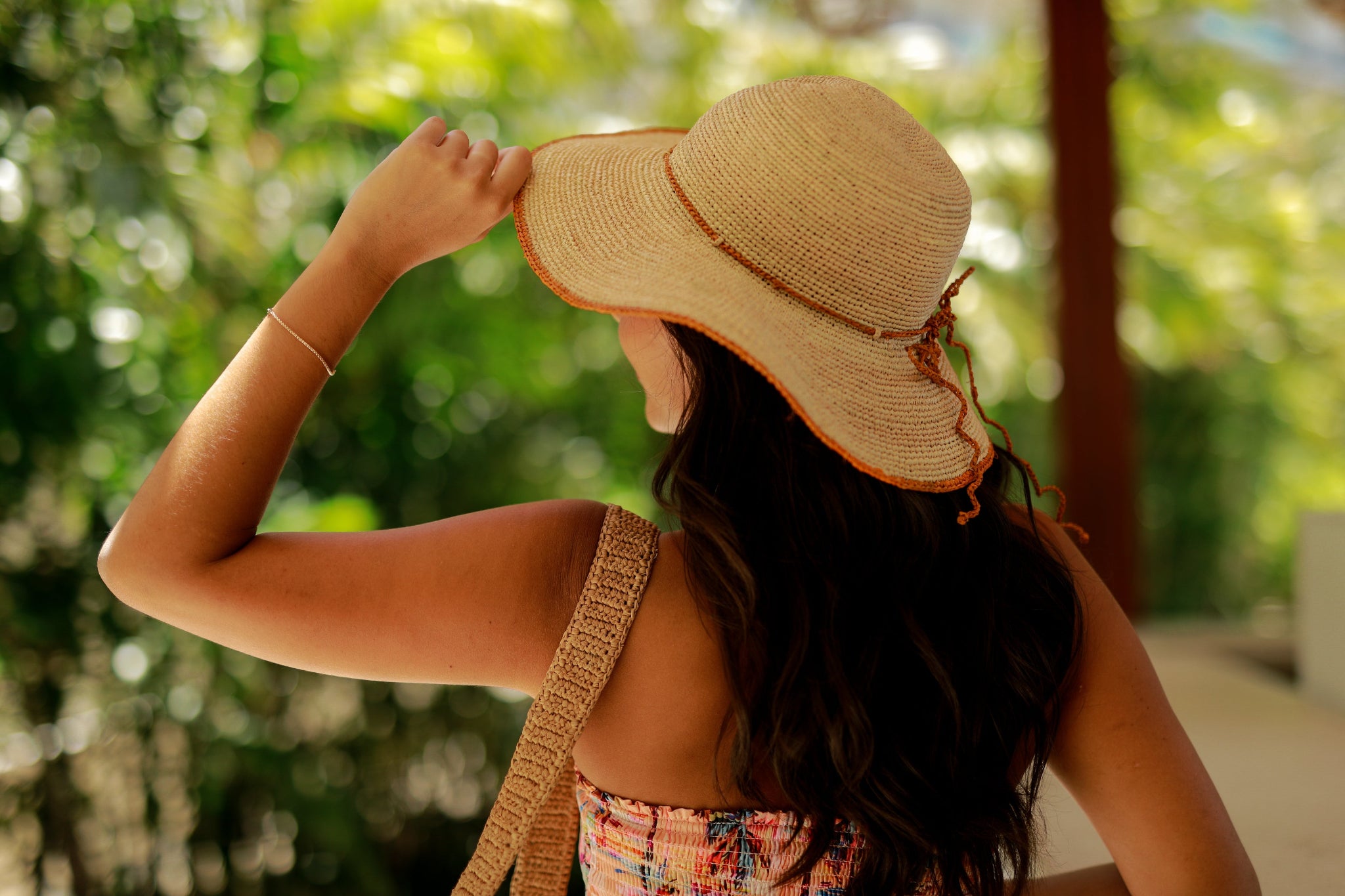 Model wearing 4 inch brim Rachel Crochet Saffron handmade straw sun hat saffron yellow trim woven edge and matching adjustable hat band on natural straw colored raffia hat - Shebobo