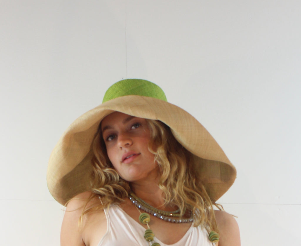 Model wearing 7" wide brim two tone lime and natural packable raffia straw hat handmade loomed raffia top half lime green, bottom half natural - Shebobo