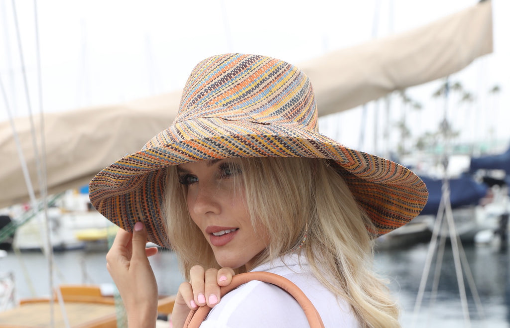 Model wearing 5" Wide Brim Blush Multi Melange Packable Straw Sun Hat handmade loomed raffia multicolor heathered swirl pattern of orange, blush pink, natural, blue, brown, yellow, etc. - Shebobo