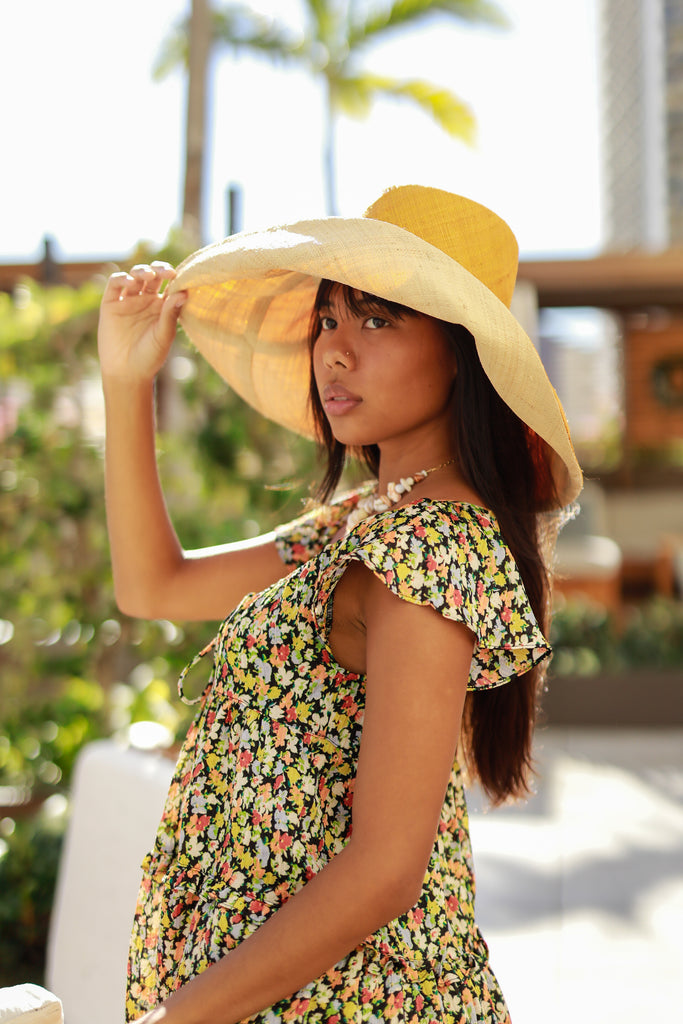 Model wearing 5" & 7" Brim Two Tone Saffron Straw Hat handmade loomed raffia color block pattern of the top half saffron orange/yellow and the bottom half natural straw color - Shebobo