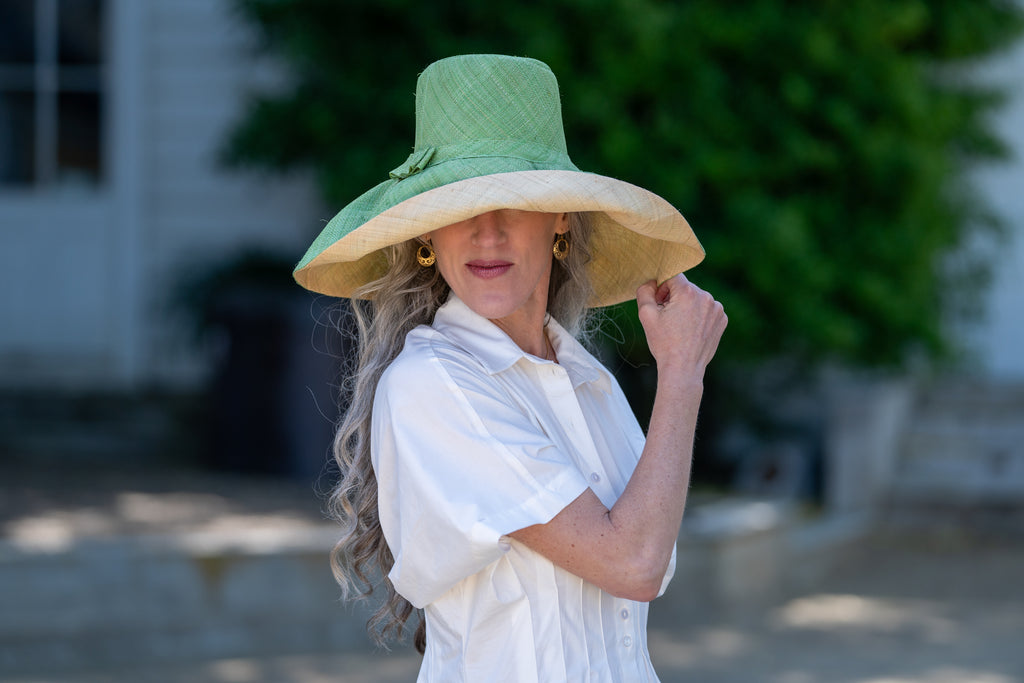 Model wearing 7 inch wide brim handmade wasabi light green top half and natural straw color bottom half two tone loomed raffia sun protection packable lightweight straw hat - Shebobo