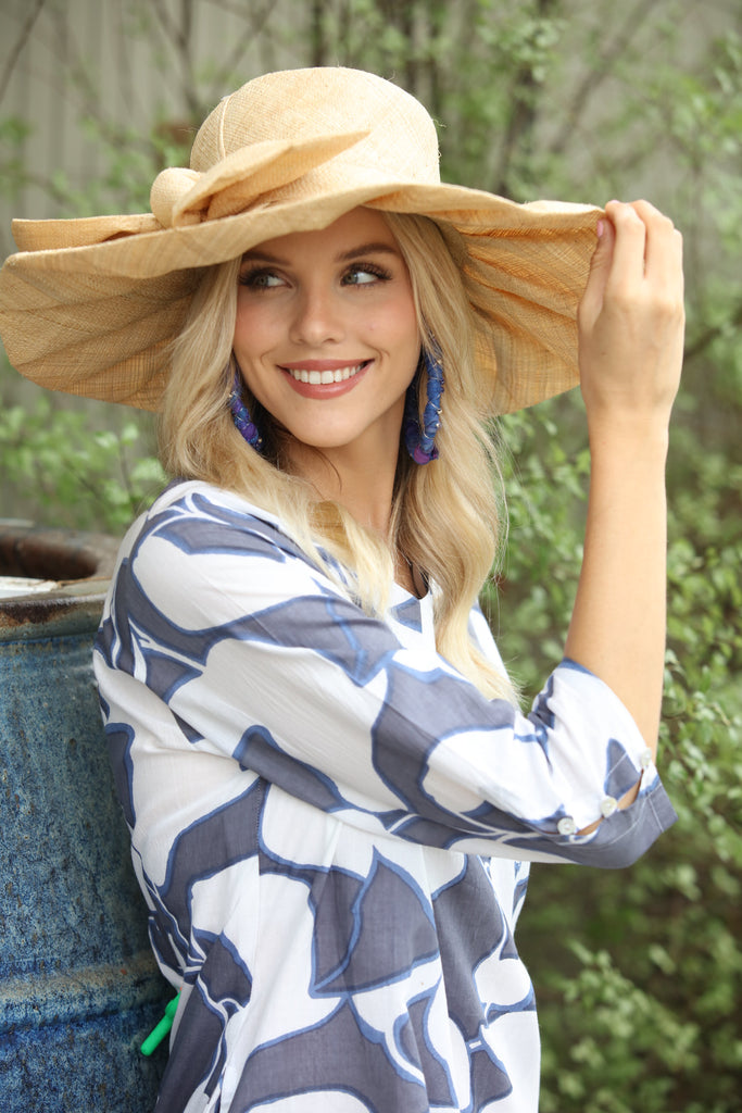 Model wearing 5" Brim Fan Straw Sun Hat with Big natural straw colored bow and matching hatband on handmade natural loomed raffia pleated wide brim hat - Shebobo