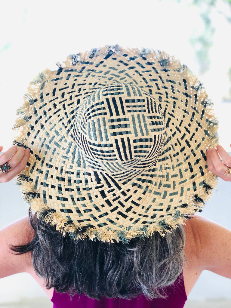 Model wearing 5" Brim Kat Grey Multi Multicolor Straw Sun Hats with Raw Fringe Edge handmade woven raffia in a crosshatch pattern of grey, black, and natural straw color with wide brim and hand brushed edge embellishment - Shebobo