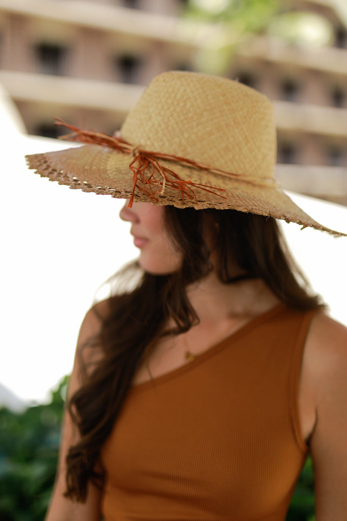Model wearing 5" Brim Vanessa Ombre Straw Sun Hat Cinnamon and Natural handmade dip dye woven raffia with the color on the outer edge of the hat brim woven into natural as it progresses towards the inner brim with solid natural on the crown and detailed zig zag edging - Shebobo
