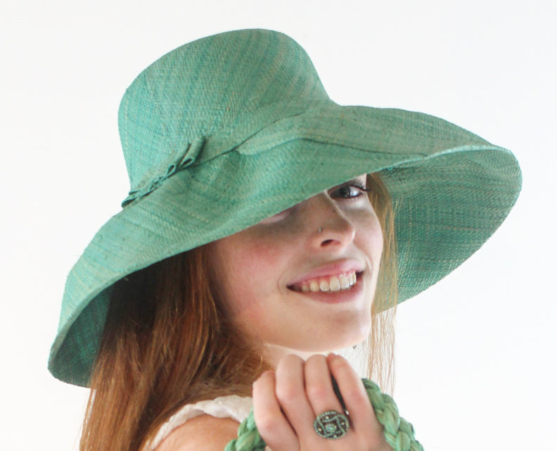Model wearing 5" Wide Brim Seafoam Packable Straw Sun Hat Handmade loomed raffia in pale blue/green seafoam - Shebobo