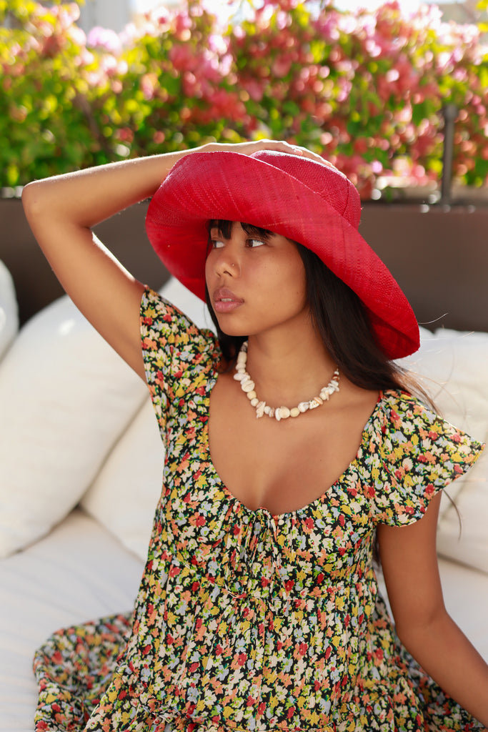 Model wearing 5" & 7" Wide Brim Natural Packable Straw Sun Hat handmade loomed raffia in a solid hue of red lightweight malleable flexible sun protection hat - Shebobo