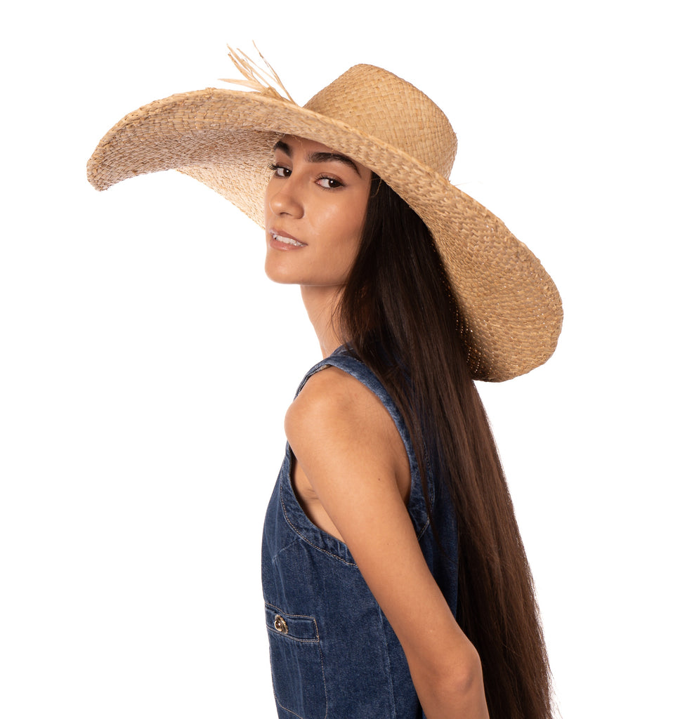 Model wearing 7" Brim Natasha Natural Woven XL Straw Sun Hat handmade woven natural raffia palm fiber in a solid hue of straw color with matching adjustable twisted raffia hat band and and extra wide brim - Shebobo