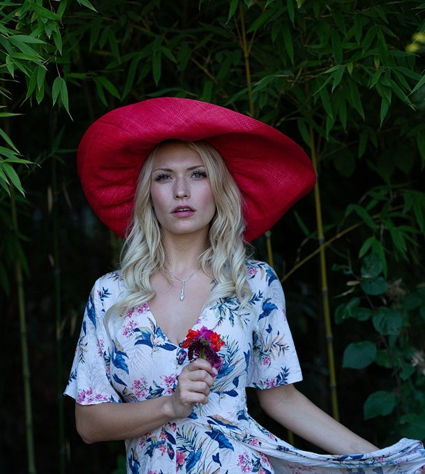 Model wearing 7" Wide Brim Natural Packable Straw Sun Hat handmade loomed raffia in a solid hue of blue lightweight malleable flexible sun protection hat - Shebobo