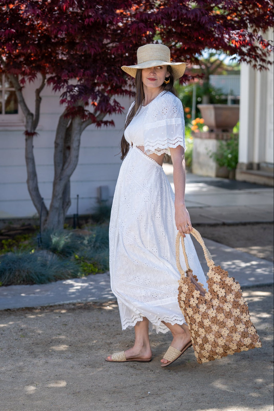 Model wearing Model wearing Amalie Two Tone Daisy Flower Crochet Straw Handbag handmade crochet mini flower buds from crochet natural raffia palm fiber in an alternating colored pattern of cappuccino tea/light/brown and natural straw color with brown internal liner and natural woven handles purse - Shebobo (with Bolero 3" Brim Crochet Straw Sun Hats)