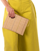 Model wearing Amelia Set of 3 Brights on Natural straw color Nesting Zippered Straw Clutches Pinstripe Pattern handmade loomed raffia in wide vertical bands of natural with multicolor narrow bands of fuchsia pink, coral orange/red, lime green, black, etc. with matching zipper and braided zipper pull with cross stitch edging in three sizes of small, medium, and large - Shebobo