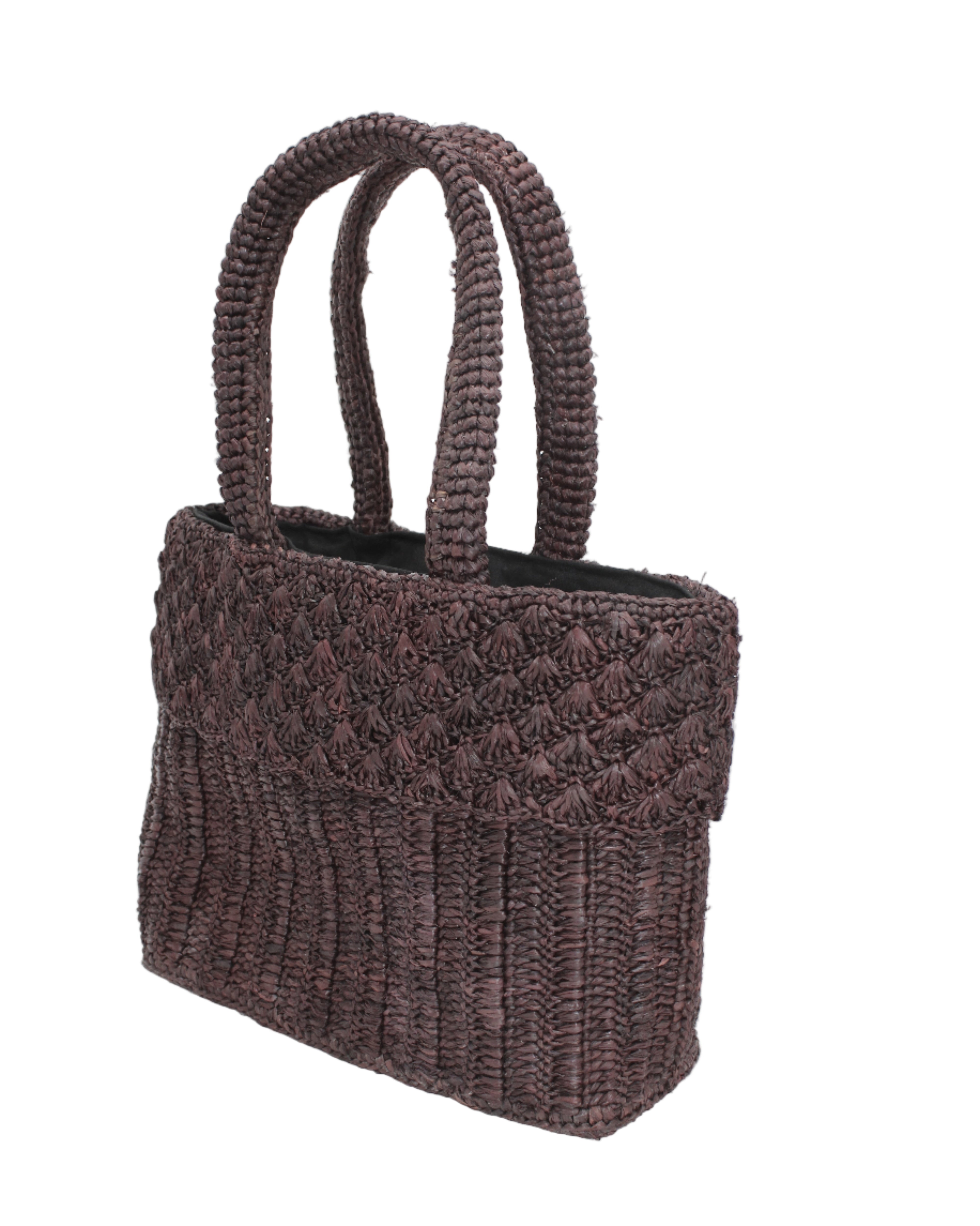 Side view Anna Petal Pattern Crochet Straw Basket Handbag handmade natural raffia palm fiber in a solid hue of Mocha chocolate/dark/brown crochet in multiple textures resulting in a subtle pattern of vertical linked bands on the bottom 2/3 of the bag, and a floral petal or shell pattern on the upper third with rolled panel of links making up the handles Beach Bag Purse - Shebobo