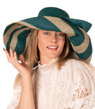 Model wearing Audrey 7" Wide Brim Teal Two Tone Wide Stripe Straw Sun Hats with Big Bow handmade loomed raffia palm fiber in a solid hue of Teal dark/blue/green on the crown and matching oversized big bow embellishment hat band, with two tone even width wide stripe pattern of teal and natural straw color that creates a swirl patterned brim - Shebobo