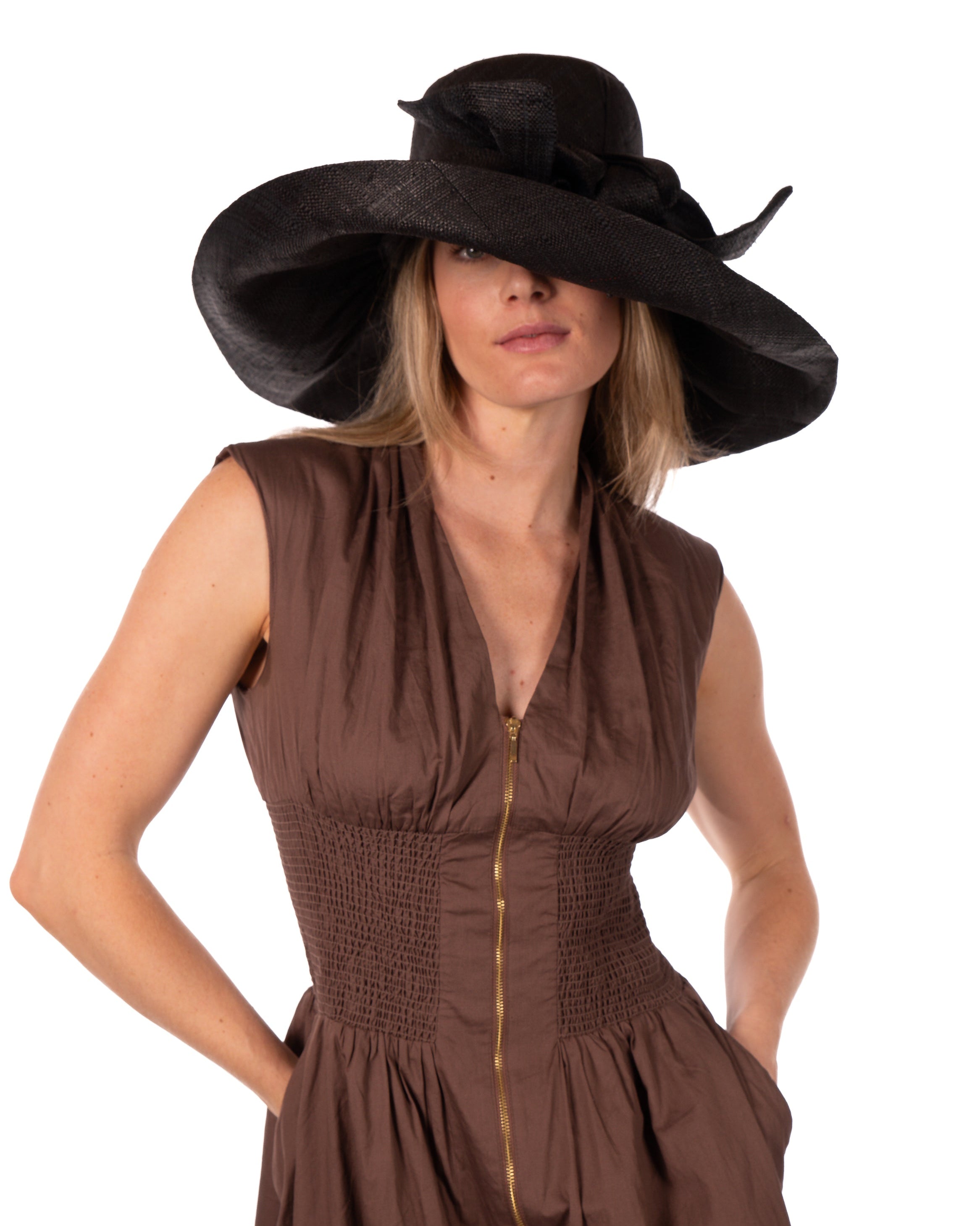 Model wearing Audrey 7" Wide Brim Solid Color Straw Sun Hats with Big Bow handmade loomed natural raffia straw fiber in a solid hue of black with matching oversized big bow embellishment hat band - Shebobo