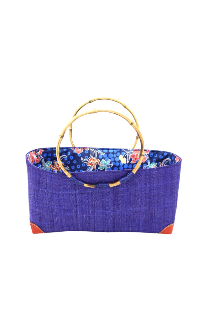 Bebe Straw Handbag with Bamboo Handle handmade loomed natural raffia palm fiber in a solid hue of Dusk dark/navy/blue with molded circular bamboo handles, leather feet, and assorted print African wax-cloth fabric liner - Shebobo