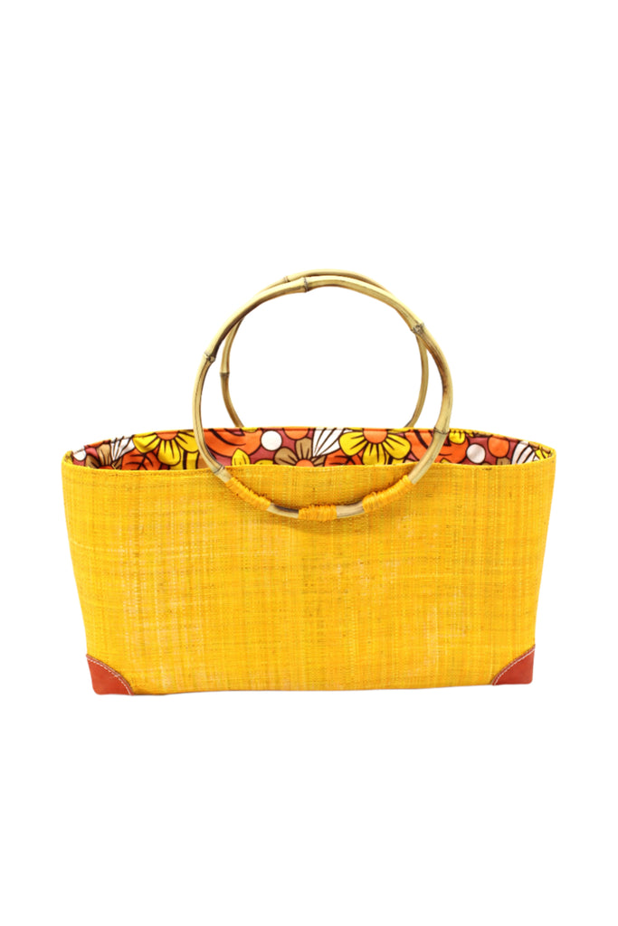 Bebe Straw Handbag with Bamboo Handle handmade loomed natural raffia palm fiber in a solid hue of saffron orange/yellow with molded circular bamboo handles, leather feet, and assorted print African wax-cloth fabric liner - Shebobo