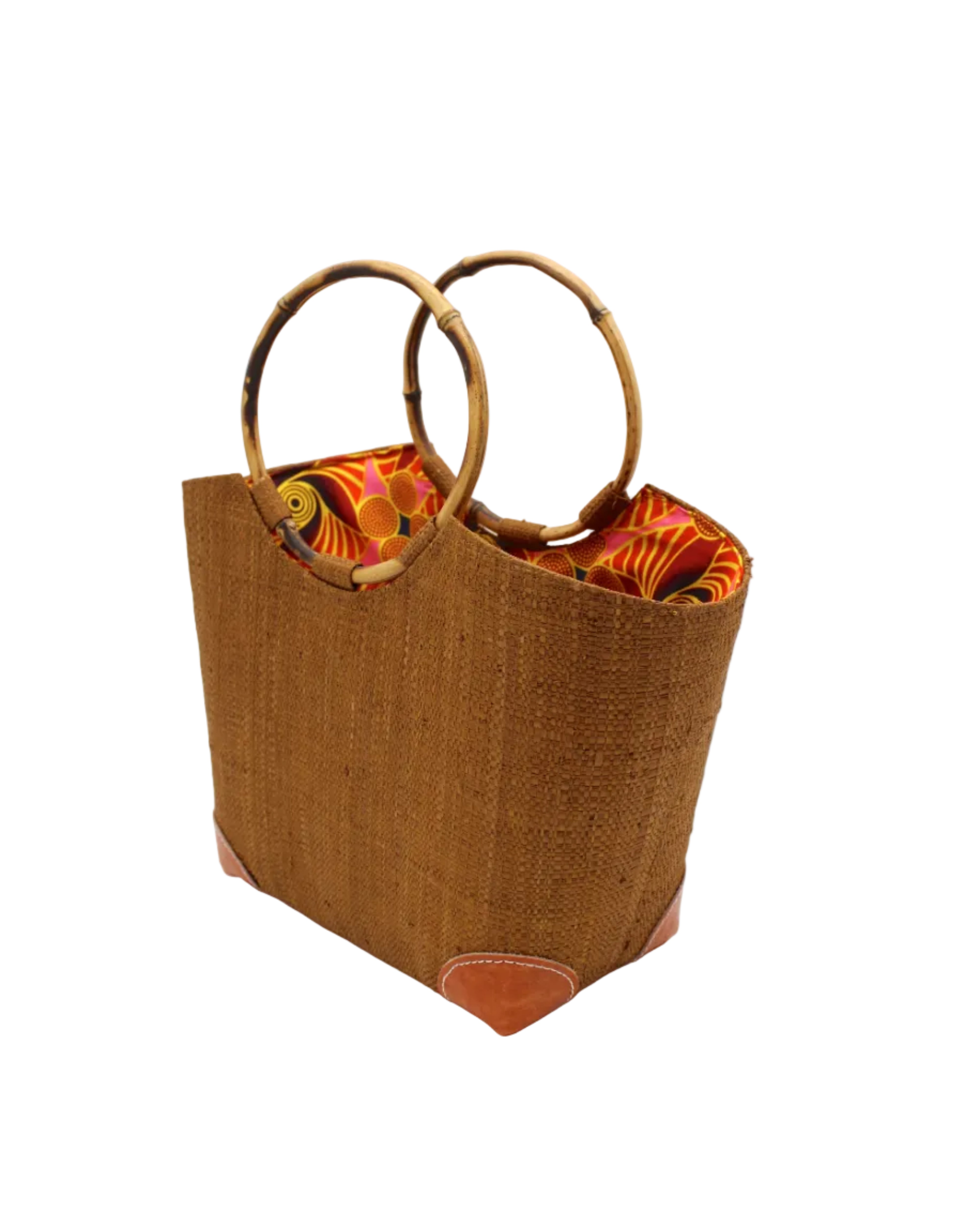 Side view Betty Straw Bucket Bag with Bamboo Handles handmade loomed natural raffia palm fiber in a solid hue of tobacco cinnamon/dark/brown with circular bamboo handles, leather feet, and colorful African Print wax cloth liner handbag purse tote - Shebobo