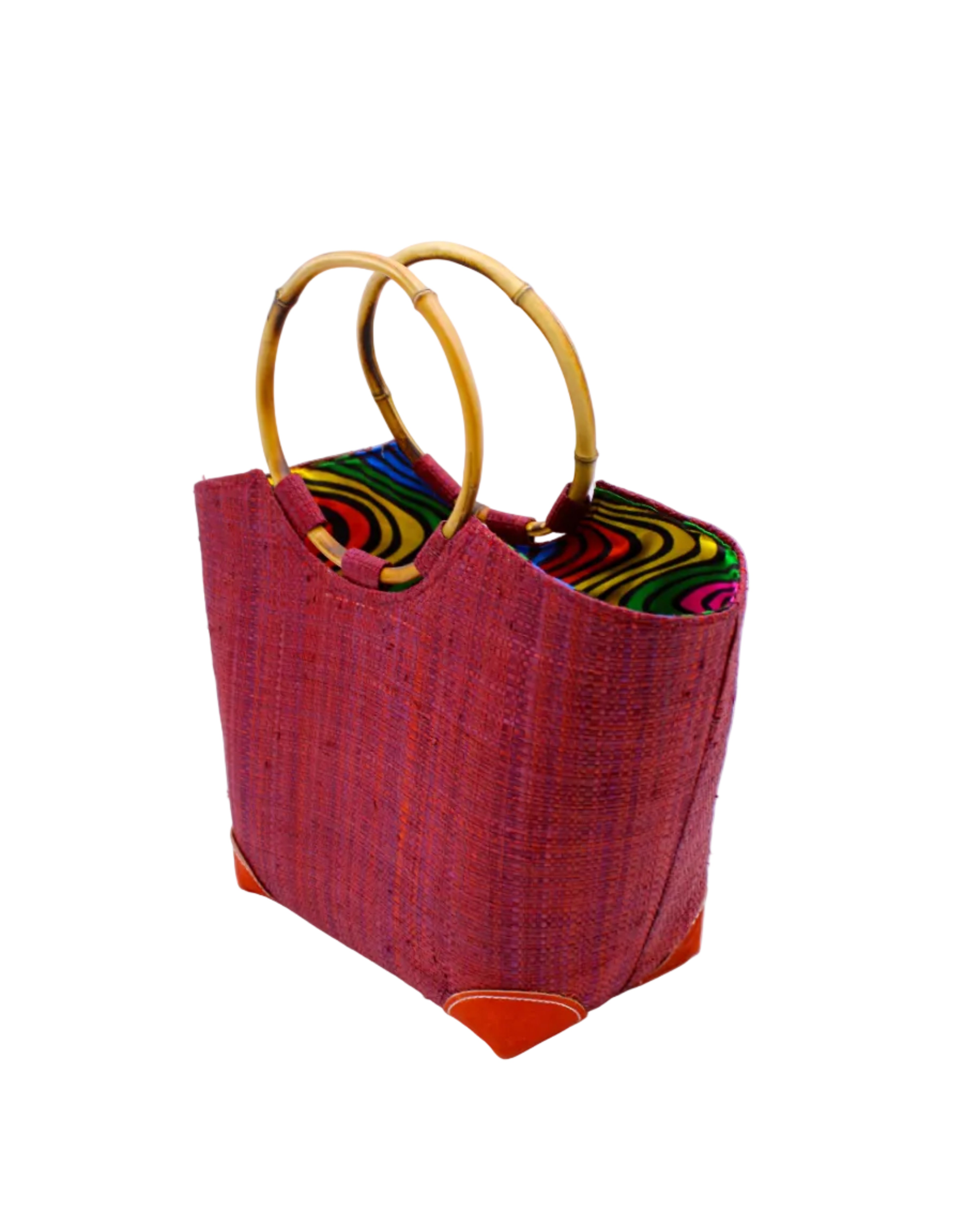 Side view Betty Straw Bucket Bag with Bamboo Handles handmade loomed natural raffia palm fiber in a solid hue of umberwine burgundy/dark/purple/red with circular bamboo handles, leather feet, and colorful African Print wax cloth liner handbag purse tote - Shebobo