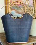 Lifestyle shot of Carmen Straw Bucket Bag Black Handmade Loomed Raffia with assorted African Print Liner, Bamboo Handles, and leather binding - Shebobo