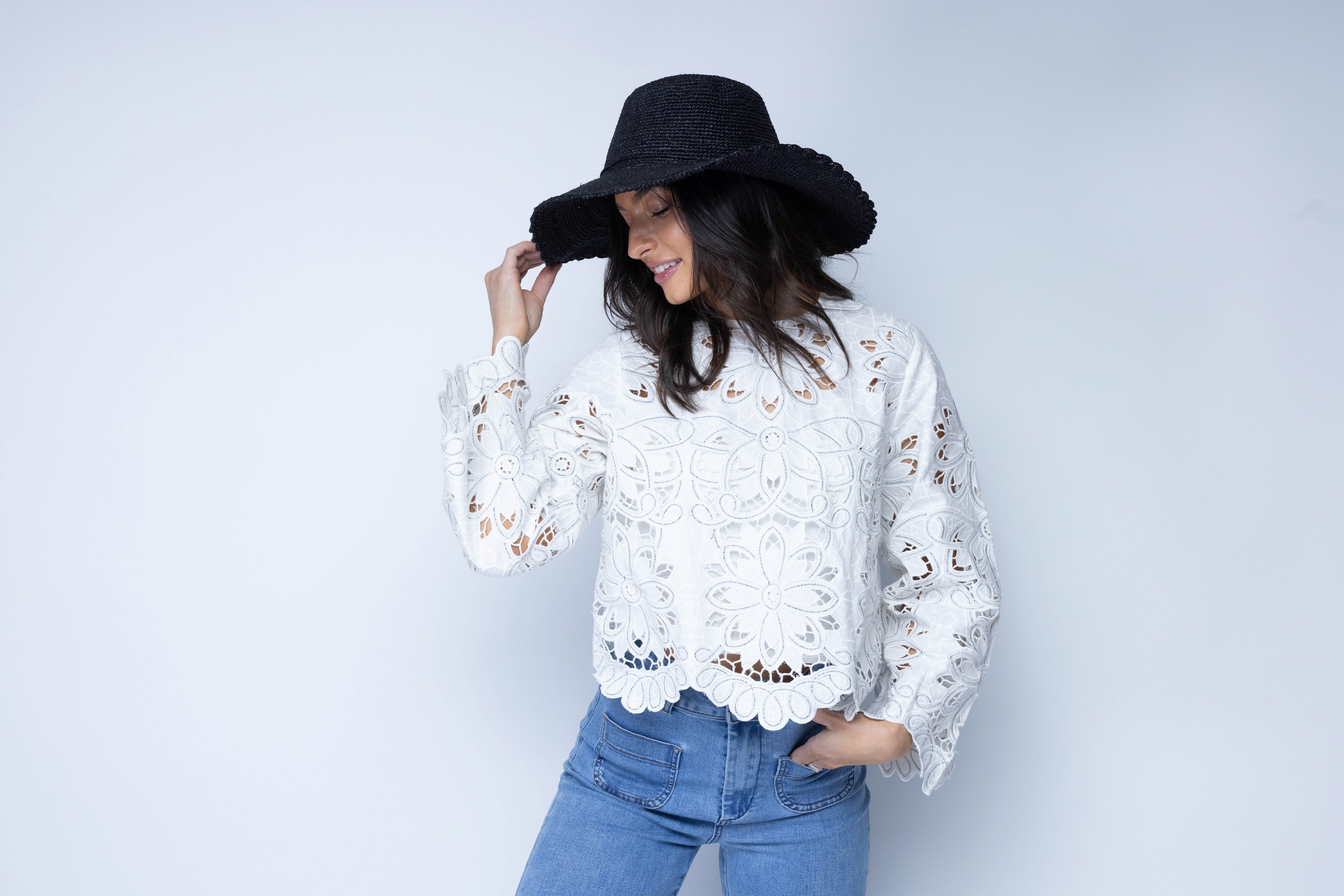 Model wearing 4" Brim Genevieve Black Crochet Straw Sun Hat with Lace Weave Edge handmade raffia palm fiber crochet solid hue black rounded crown with detailed lace weave edge and matching adjustable hat band - Shebobo