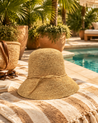 Lifestyle view Bobbi 3" Brim Crochet Bucket Raffia Straw Hats handmade natural raffia palm fiber in a subtle crochet link texture spiraling out from the top crown of the hat to the edge of the brim in a solid hue of natural straw color with matching braided adjustable hat band sun hat - Shebobo