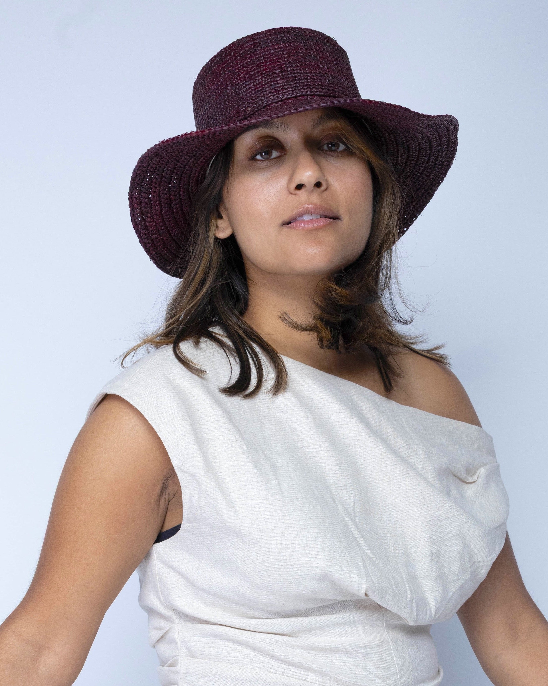 Model wearing 3" Brim Bolero Crochet Straw Sun Hats handmade crochet natural raffia palm fiber in a solid hue of mocha dark/chocolate/brown making a concentric pattern from the center top of the flattened crown spiraling out to the edge of the brim with matching adjustable raffia braid hat band - Shebobo