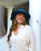 Model wearing 3" Brim Bolero Crochet Straw Sun Hats handmade crochet natural raffia palm fiber in a solid hue of turquoise blue/green making a concentric pattern from the center top of the flattened crown spiraling out to the edge of the brim with matching adjustable raffia braid hat band - Shebobo