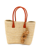 Cancun Small Sisal Basket Bag with Tassel Charm handmade natural sisal fibers woven into even width horizontal bands of cappuccino light brown and natural straw color that create a pinstripe pattern with matching knotted raffia tufts tassel charm embellishment and leather handles beach bag - Shebob