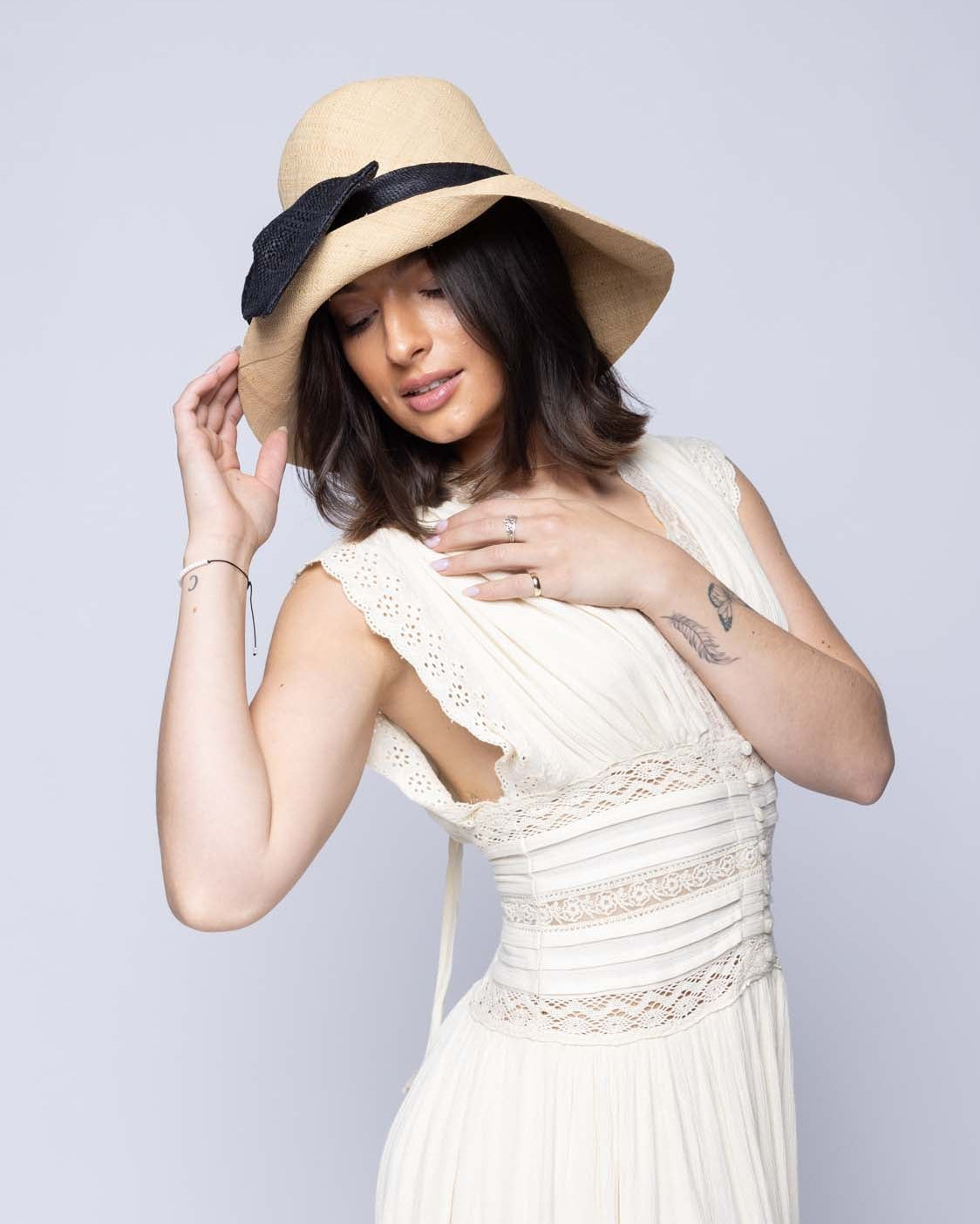 Model wearing Cara Big Bow Straw Hat Handmade loomed raffia straw hat solid natural bucket hat with large black bow - Shebobo