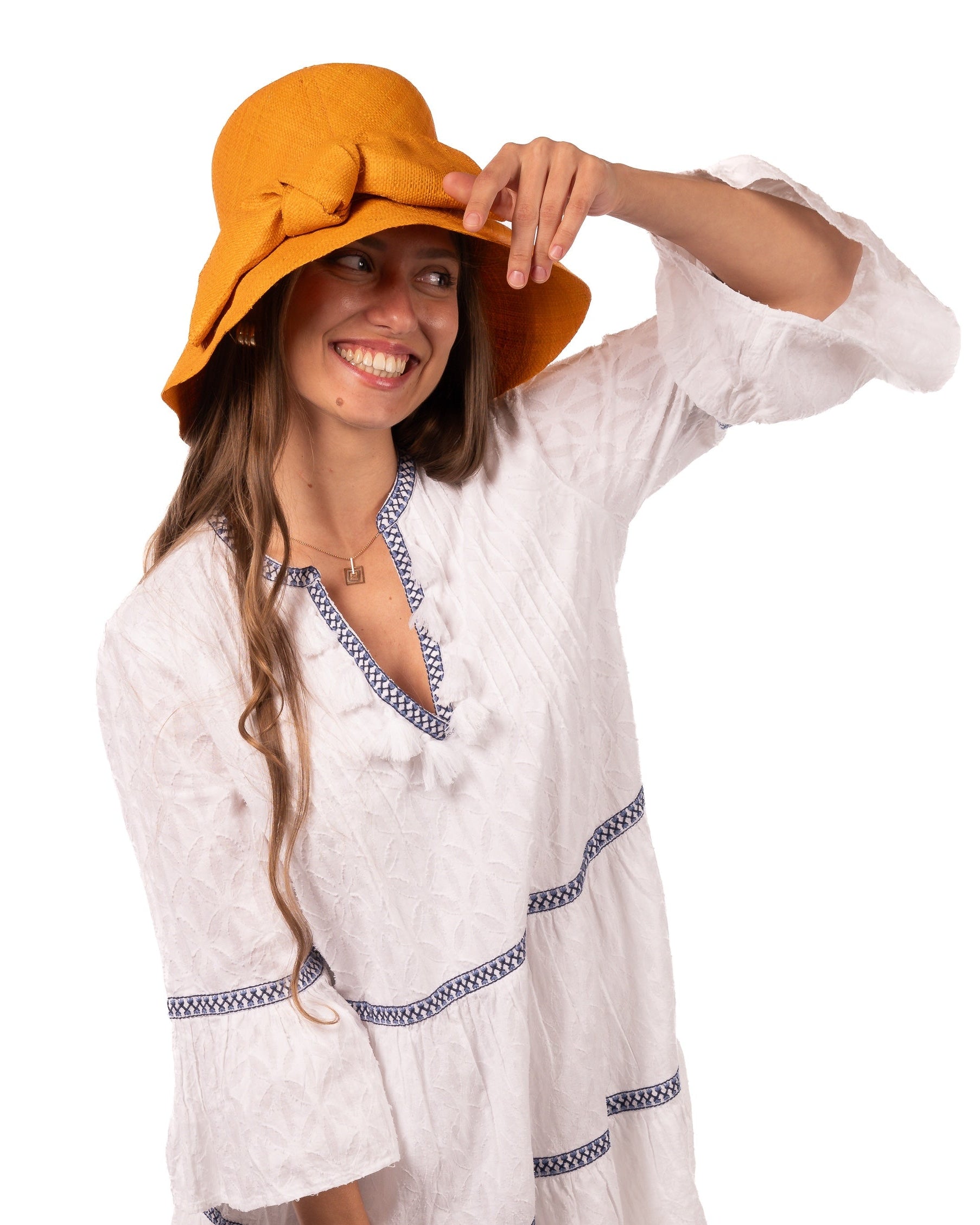Model wearing Cara Saffron big bow embellishment handmade loomed raffia in a solid hue of saffron yellow/orange straw bucket style cloche sun hat with matching oversized bow - Shebobo
